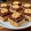 Erdnussbutter Rice Krispie Treats Rezept Zutaten: - 150 g Erdnussbutter - 150 g Butter - 300 g Marshmallows - 300 g Rice Krispies Anleitung: 1. Erdnussbutter und Butter in einem großen Topf bei mittlerer Hitze schmelzen. 2. Marshmallows hinzufügen und rühren, bis sie geschmolzen und gut vermischt sind. 3. Rice Krispies einrühren, bis alles gleichmäßig bedeckt ist. 4. Die Mischung in eine gefettete 23x23 cm große Auflaufform drücken. 5. Abkühlen lassen und in Quadrate schneiden.